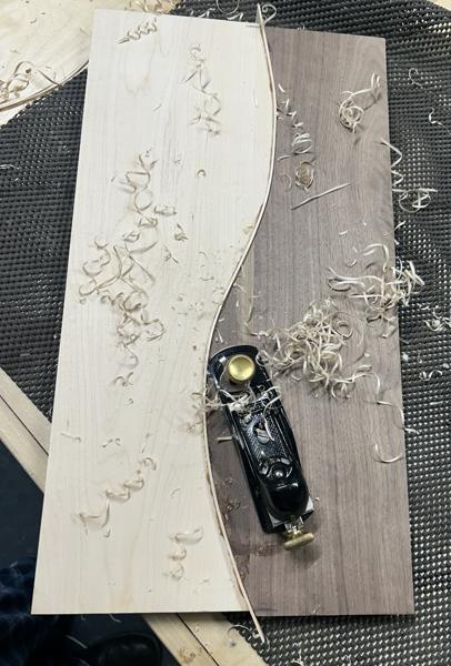 After gluing, the excess width of the strip is hand planed to flatten the glued board.